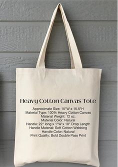 a canvas tote bag hanging on the side of a building with text that reads heavy cotton canvas tote