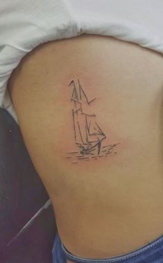 a woman with a small sailboat tattoo on her lower back side ribcage