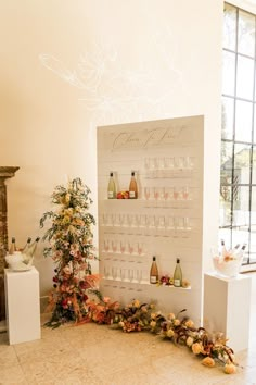 there is a wine rack with many bottles on it next to a small christmas tree