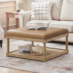 a coffee table with a book on it in a living room next to a couch