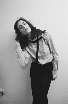 black and white photograph of a woman leaning against a wall