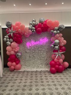 a pink and silver balloon arch with balloons