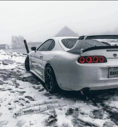 a white sports car parked on top of snow covered ground