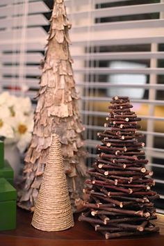 two small christmas trees sitting on top of a wooden table