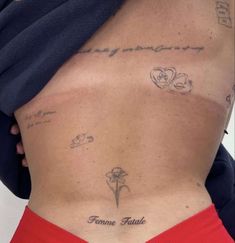 the back of a woman's stomach with tattoos on her left side and words written in cursive writing