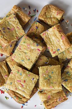 a white plate topped with brownies covered in sprinkles