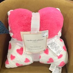 a pink and white heart shaped pillow in a cardboard box with price tags on it