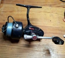 a spinning fishing reel on a wooden table