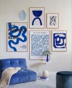 a living room with blue furniture and art on the wall