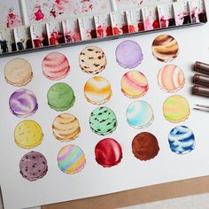 an artist's watercolor palette with different colored cookies and chocolates on it