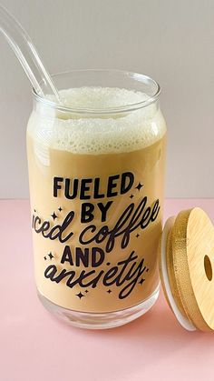 a glass jar filled with liquid next to a wooden lid that says fueled by coffee and angry