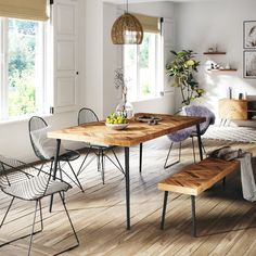 a wooden table sitting on top of a hard wood floor next to two metal chairs