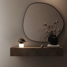 a vase with flowers on a shelf next to a mirror and a plant in front of it