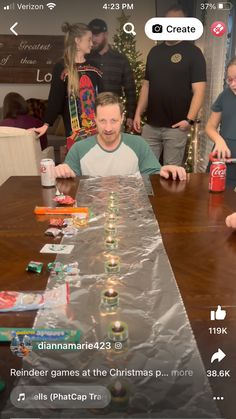 a man sitting at a long table covered in tin foil with christmas decorations on it