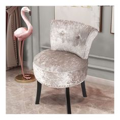 a pink flamingo standing next to a chair in a living room with tile flooring