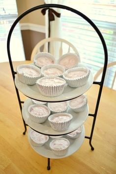 three tiered tray with cupcakes on it