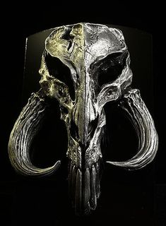 a metal skull with two horns on it's head and an open mouth in front of a black background