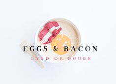 eggs and bacon in a bowl on top of a white surface with the words land of dough