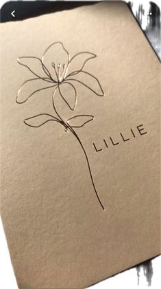 a close up of a paper with a flower on it and the word lilie written in cursive writing