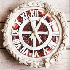 a clock made out of pie sitting on top of a wooden table