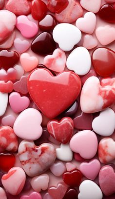 many hearts are arranged together in the shape of heart shaped candies, with different colors and sizes