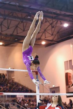 two women are performing on the uneven bars