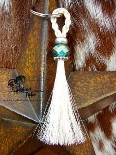 a white tassel hanging from the side of a brown and white cowhide star