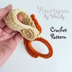 a hand holding a crochet ring with a button on it