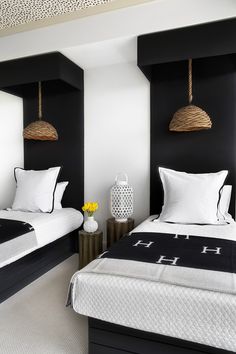 two beds in a room with black and white decor