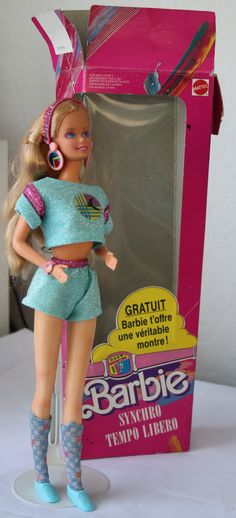 a barbie doll is standing in front of a box