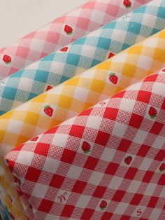 four different patterns of fabric with strawberries on them, one in red and the other in blue