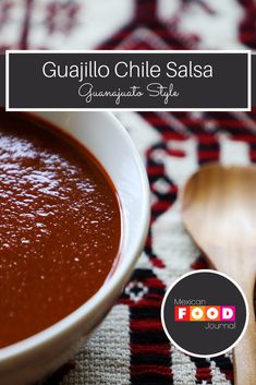 a bowl of tomato sauce with a spoon next to it on a tablecloth and the words guallo chile salsa granata style