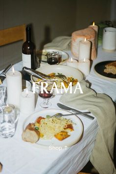 an image of a dinner table setting with food and wine on the table for people to eat