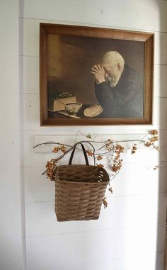 a basket hanging on the wall next to a painting