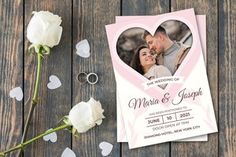 a wedding card with a heart on it next to two roses and a rose bud