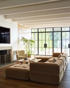 a living room filled with furniture and a flat screen tv mounted on the wall above a fireplace