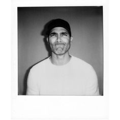 a black and white photo of a man wearing a hat