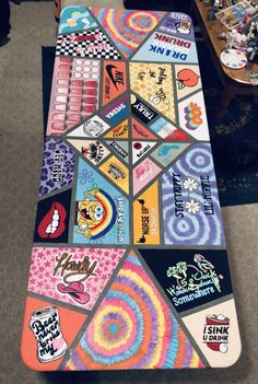 a skateboard covered in colorful stickers sitting on top of a carpeted floor