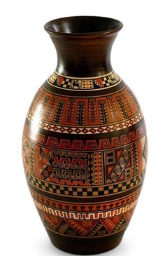 a brown and black vase sitting on top of a white table