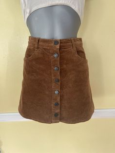 Fitted Brown Corduroy Mini Skirt, Casual Brown Corduroy Mini Skirt, Brown Corduroy Casual Mini Skirt, Brown Corduroy Bottoms With Buttons, Brown Mini Skirt With Button Closure, Brown Cotton Skirt With Buttons, Brown Corduroy Mini Skirt For Fall, Corduroy Mini Skirt With Button Closure, Casual Brown Buttoned Mini Skirt