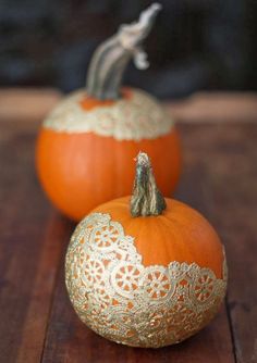 two orange pumpkins sitting on top of a wooden table