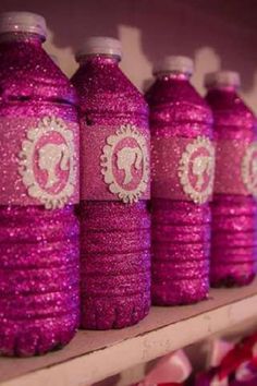 pink soda bottles are lined up on a shelf in a store, decorated with lace and sequins