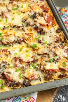 a casserole dish with meat, cheese and green onions