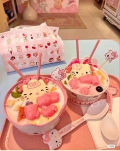 two bowls filled with ice cream and hello kitty toppings on top of a table