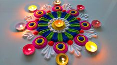 a colorful decoration with lit candles on a white surface