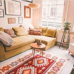 a living room with a green couch and colorful rugs on the floor in front of a window