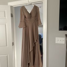 a dress hanging on a hanger next to a door in a room with white walls