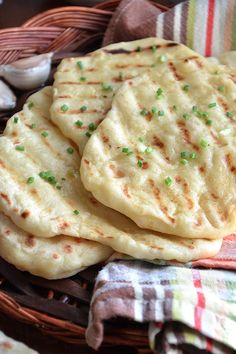 three flat breads sitting in a wicker basket