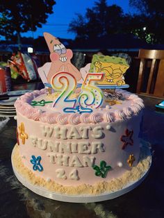 a birthday cake that has the number twenty five on it and is decorated with cartoon characters