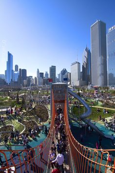 many people are walking on the bridge over the water and in the cityscape